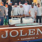 2022 - Aboard "Jolene", owner J.R. Adams, Captain Drew Rhonehouse and crew celebrate their first leg win of the “Quest for the Crest".